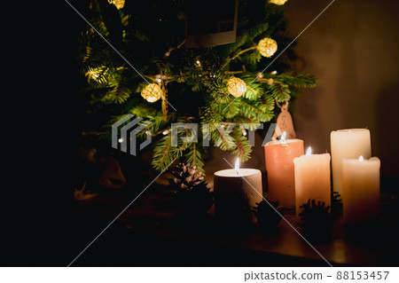many lighted candles near the Christmas tree. Photo in dark colors. Copy space many lighted candles near the Christmas tree. Photo in dark colors. Copy space 88153457