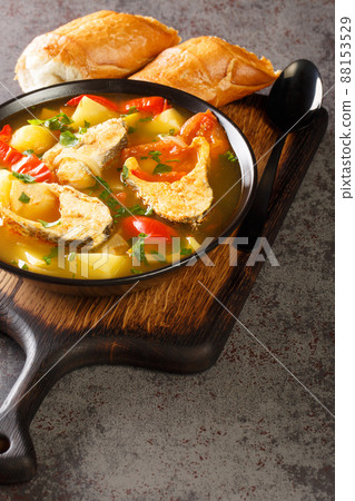 Caldeirada de peixe Portuguese fish stew with potatoes, peppers, tomatoes and onions close-up in a bowl. Vertical 88153529