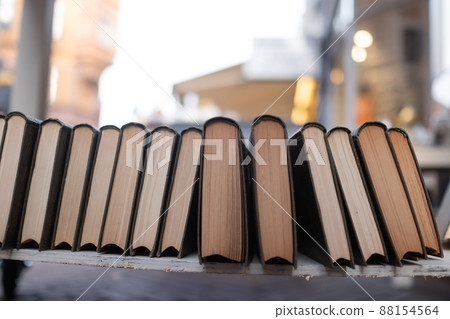 Row of books standing on bookshelf outdoor. Row of books standing on bookshelf outdoor. 88154564