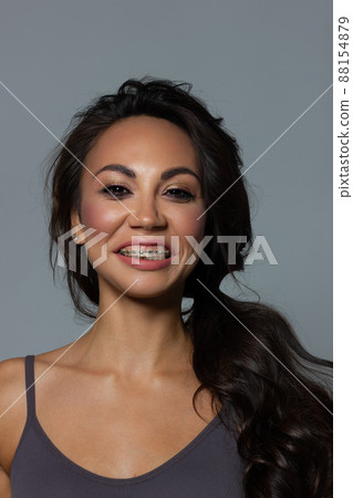 Beautiful brunet model woman face with brown eyes and perfect make-up . Portrait of beauty young brunet girl with pink lips. Female face with clear skin close-up. Skincare 88154879