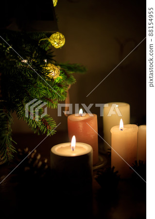 many lighted candles near the Christmas tree. Photo in dark colors. Copy space many lighted candles near the Christmas tree. Photo in dark colors. Copy space 88154955