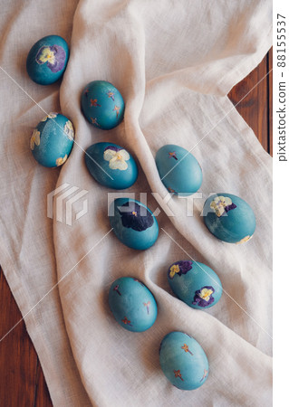 Pressed flower Easter eggs on beige tablecloth. 88155537