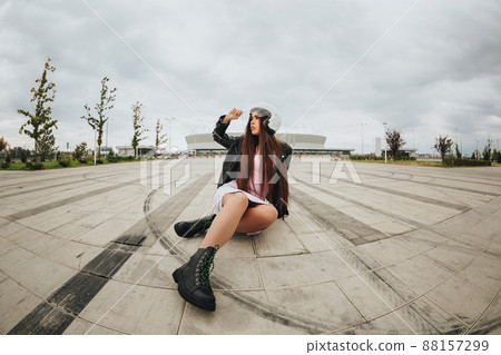 Young beautiful woman female biker in protective helmet sitting on road at stadium Young beautiful woman female biker in protective helmet sitting on road at stadium 88157299
