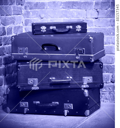 Old vintage suitcases isolated near brick wall Old vintage suitcases isolated near brick wall 88157345