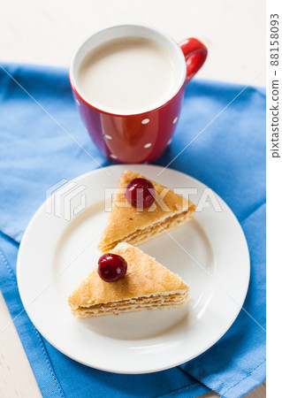 Sponge cake with cherries on a plate and cup of coffee Sponge cake with cherries on a plate and cup of coffee 88158093
