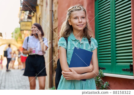 Outdoor portrait of a preteen female student on a city street. Outdoor portrait of a preteen female student on a city street. 88158322