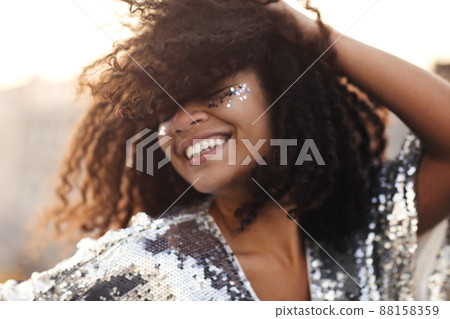 Outdoor portrait of happy glamour african american party girl with glitter on face Outdoor portrait of happy glamour african american party girl with glitter on face 88158359