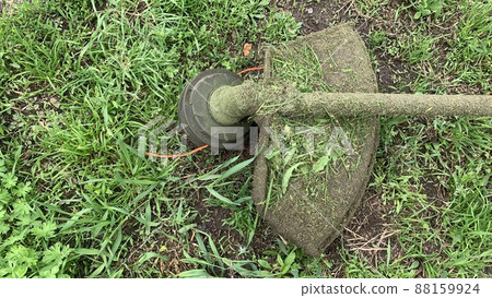 Brushcutter, Trimmer mows grass close-up. Brushcutter mower lying on green grass. Copyspace Brushcutter, Trimmer mows grass close-up. Brushcutter mower lying on green grass. Copyspace 88159924
