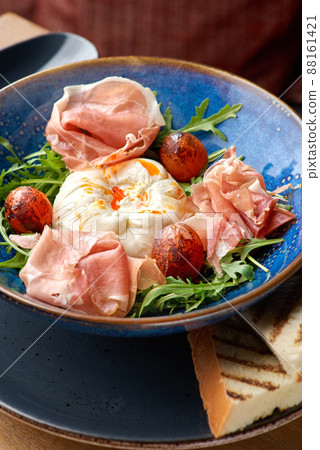 Buratta salad with tomatoes and prosciutto or jamon. Buratta salad with tomatoes and prosciutto or jamon. 88161421