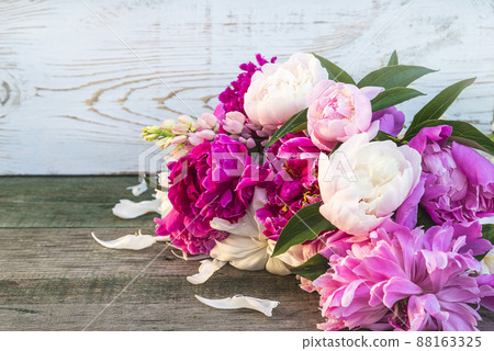 Beautiful bunch of pink, purple and white peonies on wooden rustic background Beautiful bunch of pink, purple and white peonies on wooden rustic background 88163325