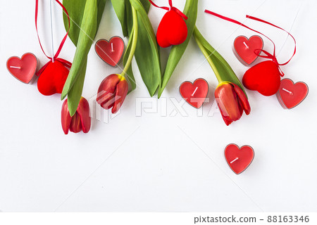 Valentine's day greeting card; Red tulips and candles shape heart on white background; space for text Valentine's day greeting card; Red tulips and candles shape heart on white background; space for text 88163346