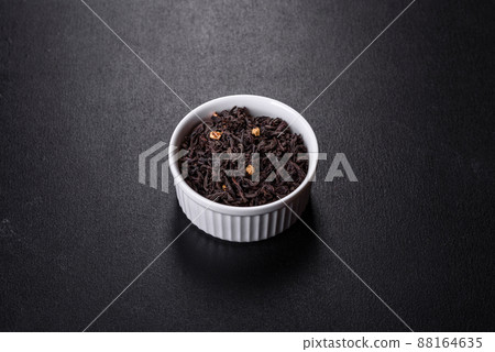 Black Ceylon tea - Top view of black tea background with green leaves Black Ceylon tea - Top view of black tea background with green leaves 88164635