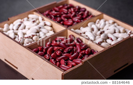 Beans of red and white dry raw beans on a dark concrete background 88164646