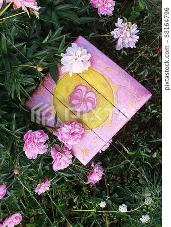 Old furniture restauration. Handmade old wooden stool painted with acrylic paints in summer garden in countryside with blooming beautiful peony flowers. Old furniture restauration. Handmade old wooden stool painted with acrylic paints in summer garden in countryside with blooming beautiful peony flowers. 88164796