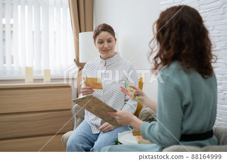 Psychologist analyzes associations on metaphorical cards in a session with a patient. Psychologist analyzes associations on metaphorical cards in a session with a patient. 88164999