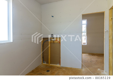 Installing gypsum plasterboard drywall for walls in apartment is under construction 88165119