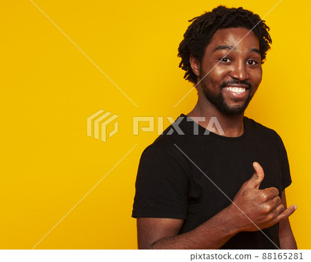young handsome african american guy student posing cheerful and gesturing on yellow background, lifestyle people concept young handsome african american guy student posing cheerful and gesturing on yellow background, lifestyle people concept 88165281