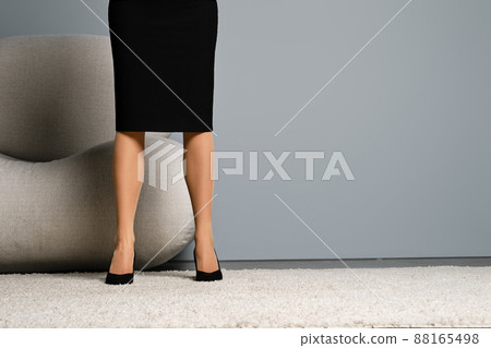 Cropped image of a woman in beige pantyhose and black pencil skirt 88165498