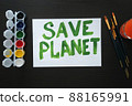 The poster with the call to save the planet is painted in bright green paint on white sheet. Rally, appeal, picket 88165991