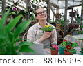 Young woman sells flowers and seedlings via video link on laptop via the Internet. Gardening, sales 88165993