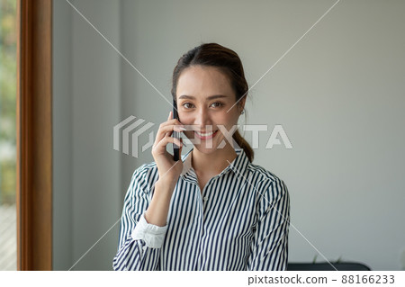 Portrait Female Entrepreneur. Cheerful asian Businesswoman Talking On Phone In Modern Office. Portrait Female Entrepreneur. Cheerful asian Businesswoman Talking On Phone In Modern Office. 88166233
