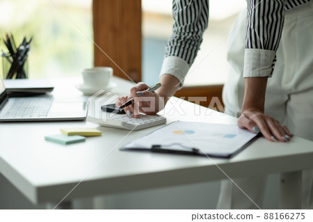 Close up Business woman using calculator and laptop for do math finance on wooden desk, tax, accounting, statistics and analytical research concept Close up Business woman using calculator and laptop for do math finance on wooden desk, tax, accounting, statistics and analytical research concept 88166275