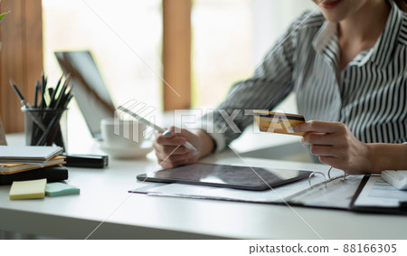 technology, asian woman online shopping concept - happy smiling woman with tablet pc computer and credit card at home technology, asian woman online shopping concept - happy smiling woman with tablet pc computer and credit card at home 88166305