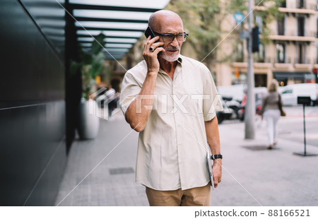 Serious adult man in eyeglasses talking on cellphone on street 88166521