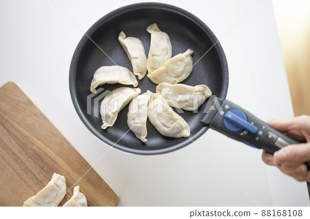 Bake handmade raw dumplings in a frying pan 88168108