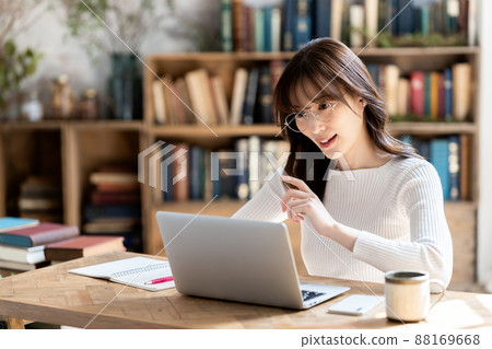 Woman with glasses having an online meeting in a chic room Woman with glasses having an online meeting in a chic room 88169668