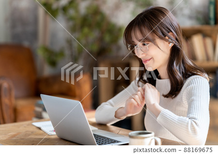 Woman with glasses having an online meeting in a chic room Woman with glasses having an online meeting in a chic room 88169675