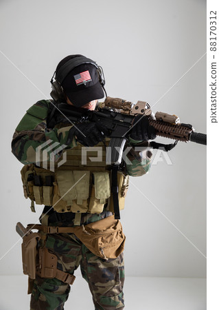Military personnel holding a gun 88170312