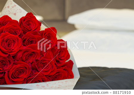 bouquet of red roses on the bed in a hotel room for honeymoon. romantic meeting of guests at the hotel. bouquet of red roses on the bed in a hotel room for honeymoon. romantic meeting of guests at the hotel. 88171910