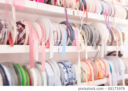 Colored ribbons on needlework store shelves 88173976