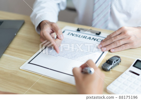Insurance concept the male dealer suggesting his customer to sign the contract of car purchasing Insurance concept the male dealer suggesting his customer to sign the contract of car purchasing 88175196