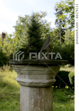 Very old sundial shows time in dense vegetation forest 88176111