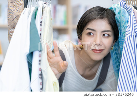 A young female fashion editor smiling out of her office hanger rack outfit A young female fashion editor smiling out of her office hanger rack outfit 88176246