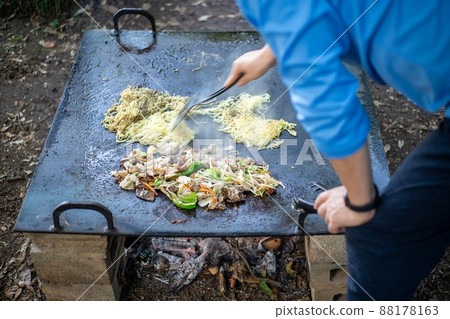 A man making yakisoba on a bonfire A man making yakisoba on a bonfire 88178163
