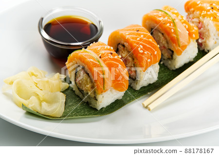 Sushi and soy sauce in a white bowl and wooden chopsticks white table. Japanese food. Japanese seafood Sushi Set. Sushi bar Menu. Sushi and soy sauce in a white bowl and wooden chopsticks white table. Japanese food. Japanese seafood Sushi Set. Sushi bar Menu. 88178167