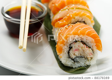 Sushi and soy sauce in a white bowl and wooden chopsticks white table. Japanese food. Japanese seafood Sushi Set. Sushi bar Menu. Sushi and soy sauce in a white bowl and wooden chopsticks white table. Japanese food. Japanese seafood Sushi Set. Sushi bar Menu. 88178169