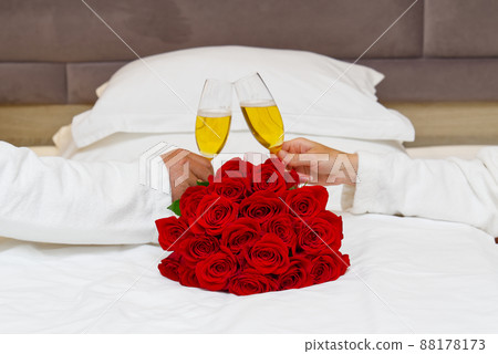 bouquet of red roses on the bed in a hotel room for honeymoon. romantic meeting of guests at the hotel. bouquet of red roses on the bed in a hotel room for honeymoon. romantic meeting of guests at the hotel. 88178173