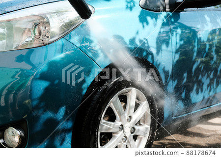 Car wash at home alone. Car wash high pressure close-up. A man washes a green car. Car wash at home alone. Car wash high pressure close-up. A man washes a green car. 88178674