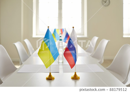 Table with Ukrainian and Russian flags in empty conference room before negotiation Table with Ukrainian and Russian flags in empty conference room before negotiation 88179512
