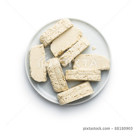 Sweet tahini halva on plate. Turkish dessert isolated on white background. 88180903
