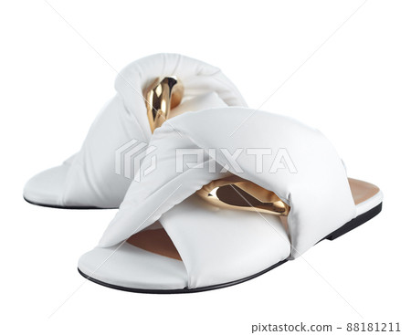 Infinitely beautiful women's sandals made of snow-white genuine leather, decorated with large links of a gold chain, isolated on a white background. Fashionable shoes. 88181211