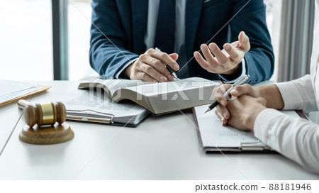 Male lawyer is pointing on legal document to explaining about consultation terms and condition to businesswoman before signing on contract at law firm 88181946