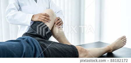 Male patient lying on the bed to getting healing treatment and rehabilitation injured knee and legs 88182172