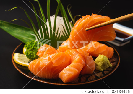 Sashimi, Salmon, Japanese food chopsticks and wasabi on the table Sashimi, Salmon, Japanese food chopsticks and wasabi on the table 88184496