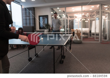 Two young start up business man playing table tennis at modern creative office space people group have meeting and brainstorming in background 88184594