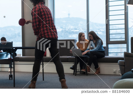 Two business women sitingt in a modern coworking space on a break from work and relax using a laptop. Selective focus Two business women sitingt in a modern coworking space on a break from work and relax using a laptop. Selective focus 88184600